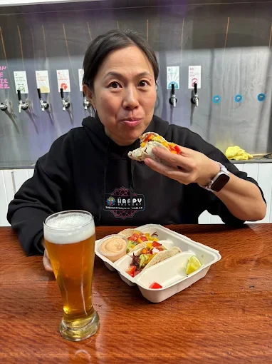 Happy guest with tacos and a beer - Freak Eats