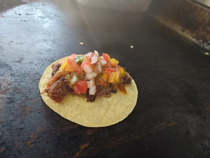 Taco topped with fresh salsa on the grill - Freak Eats food truck gallery